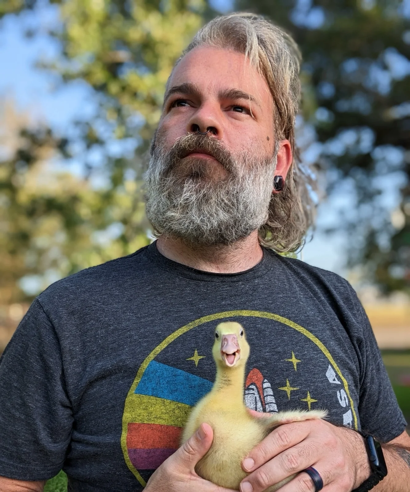 Joshua Butner outdoors, holding a duck.